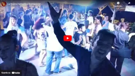 Animatori Feel Good Show che guidano gli ospiti in balli di gruppo durante una serata speciale in un camping, tra musica, energia e tanto divertimento<br /><br />