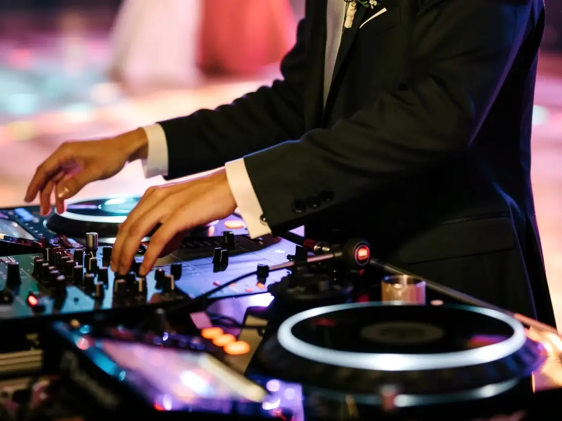 DJ che suona durante un matrimonio a Teramo con ospiti che ballano e atmosfera elegante.<br /><br />