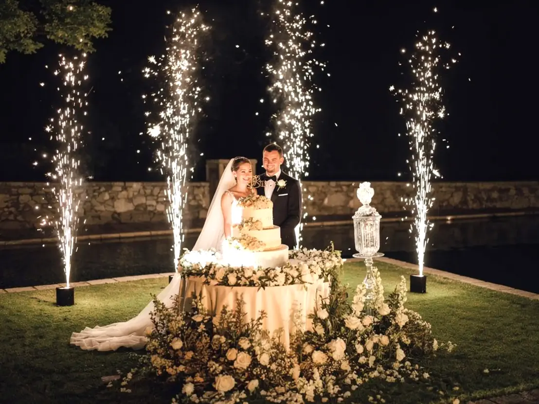 Torta Nuziale con fontane luminose fredde durante un matrimonio divertente ad Ascoli Piceno con DJ set e invitati che festeggiano.<br /><br />
