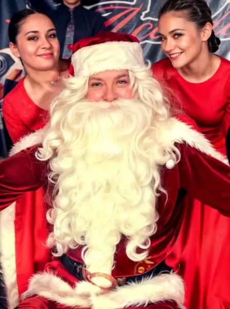 Babbo Natale con animatrici e bambini per feste ed eventi Babbo Natale insieme ad animatrici che intrattengono bambini in un centro commerciale
