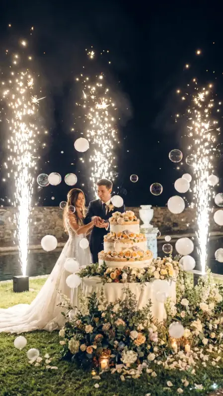 Bolle di sapone di vapore bianco con fontane fredde luminose per torta di matrimonio durante un evento indimenticabile