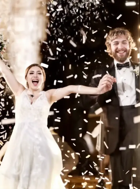 Coriandoli bianchi e colorati sparati sul palco durante un matrimonio