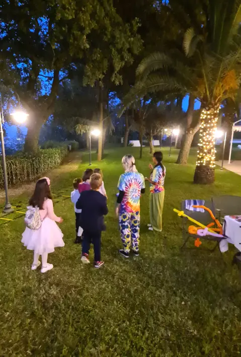 Gruppo di bambini che partecipano a un gioco organizzato da un animatore durante una festa