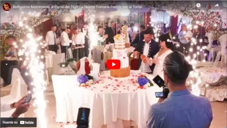 Fontane fredde luminose che illuminano il taglio della torta durante un matrimonio al coperto, creando un effetto scenografico spettacolare<br /><br />