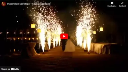 Gli sposi attraversano una passerella illuminata da scintille e fontane fredde, creando un momento emozionante e scenografico durante il matrimonio<br /><br />