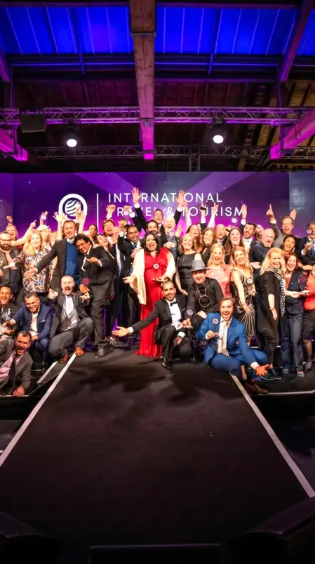 Premiazione ospiti durante una cena di gala aziendale in una sala elegante con luci calde e allestimento raffinato.
