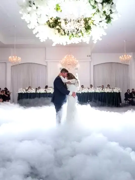 Una coppia di sposi balla romanticamente sopra un tappeto di nuvole creato con la dry ice low fog machine, per un effetto scenografico spettacolare