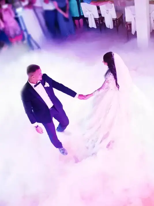 Gli sposi ballano emozionati sotto le luci romantiche del ricevimento, creando un momento magico e indimenticabile per il loro matrimonio